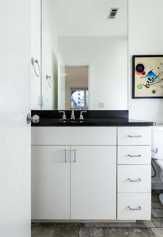 2910 Woodside Street Dallas, TX 75204 - Photo 10 of 24 a bathroom with a sink and a mirror