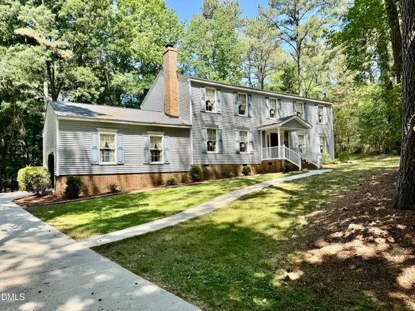 a view of a house with a yard patio and tree
