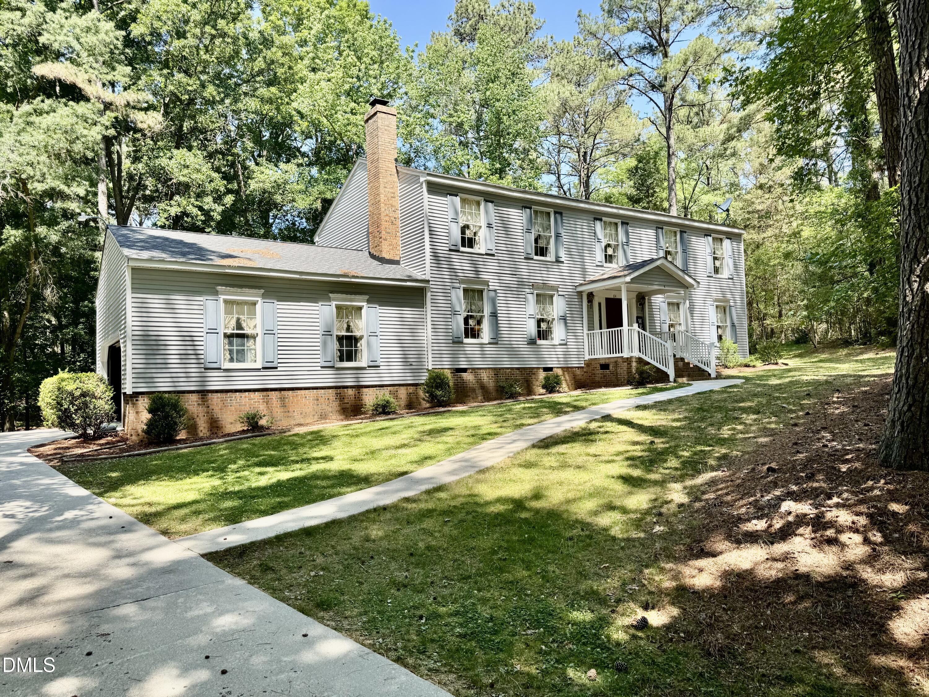 a view of a house with a yard patio and tree