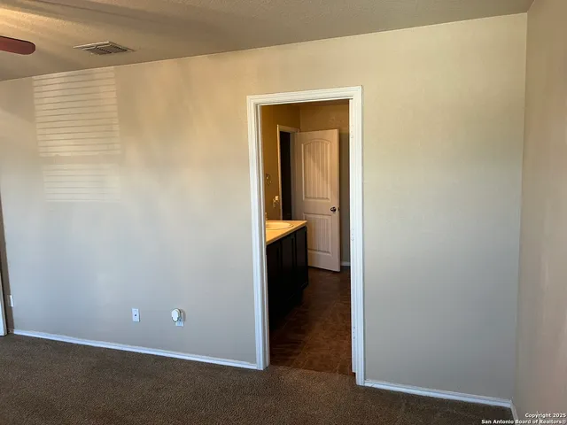 a view of an empty room with closet and a window