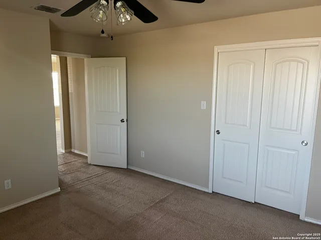 an empty room with chandelier fan