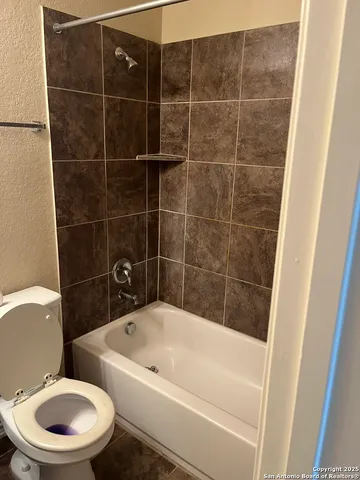 a white bath tub sitting next to a white toilet and sink