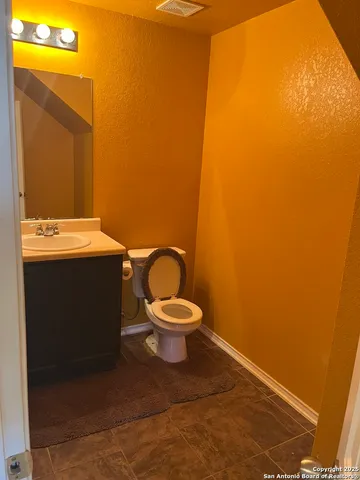 a bathroom with a toilet a sink and a mirror