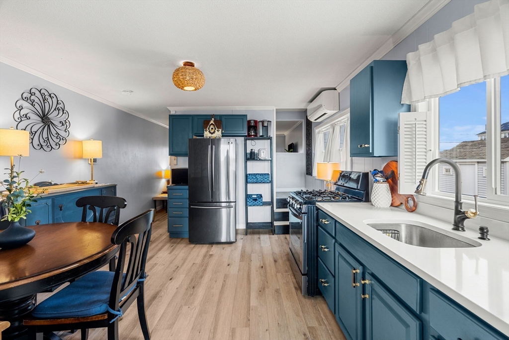a kitchen with refrigerator and wooden floor