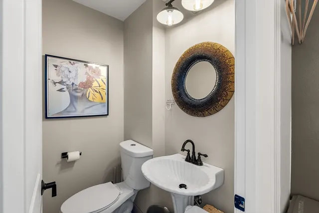 a bathroom with a toilet a sink and a mirror