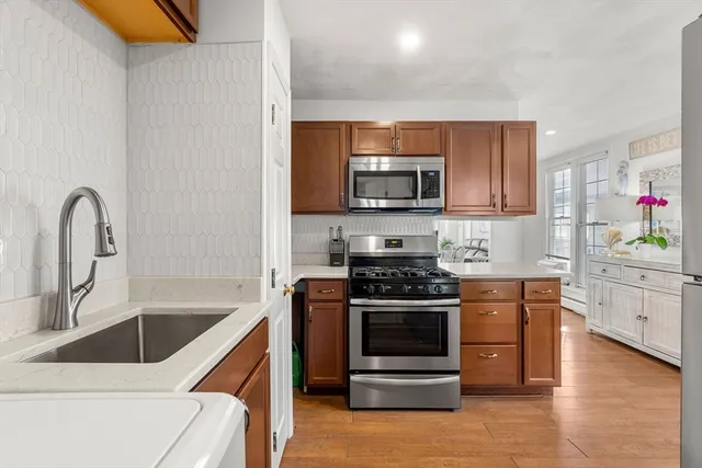 a kitchen with stainless steel appliances granite countertop a stove a sink and a microwave