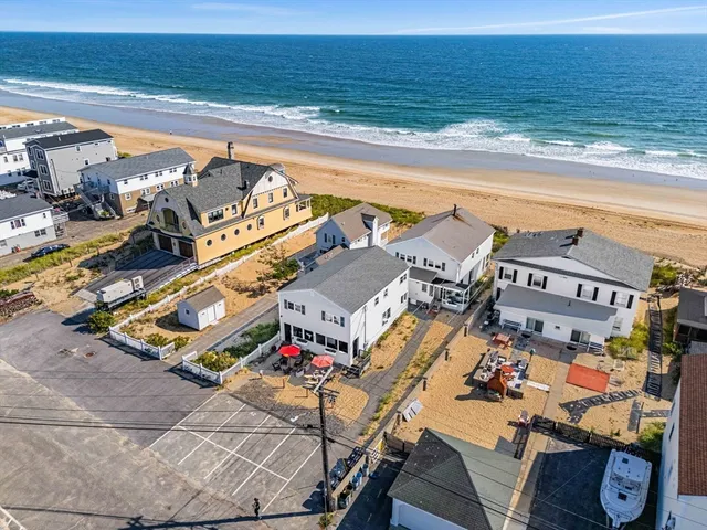 a view of a swimming pool with outdoor seating and ocean view