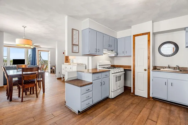 a kitchen with wooden floors and white appliances