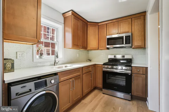 a kitchen with stainless steel appliances granite countertop a stove microwave and sink