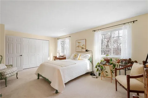 a spacious bedroom with two beds and chair