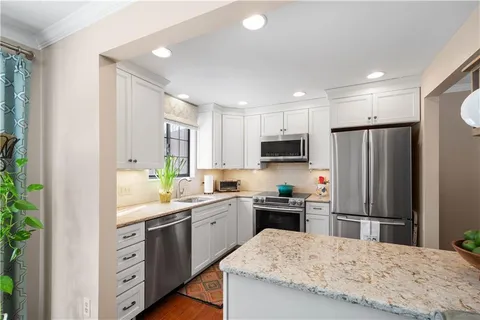 a kitchen with a sink a refrigerator and cabinets