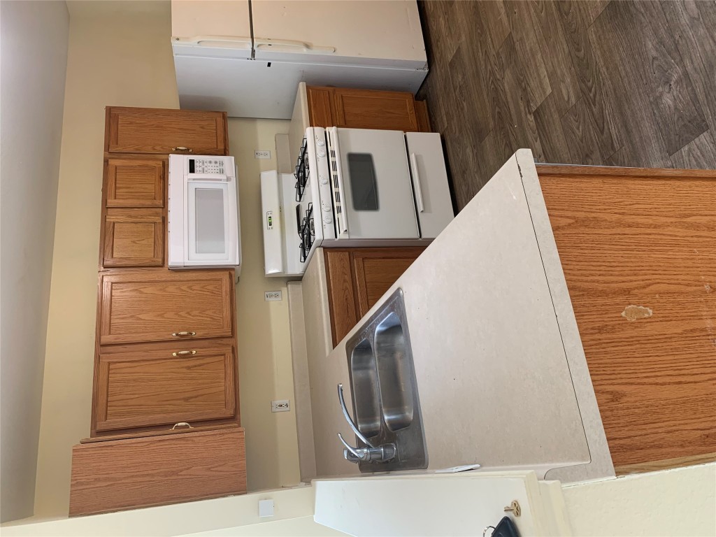 11904 Lima Drive Manor, TX 78653 - Photo 3 of 10 a kitchen with a stove a sink and a refrigerator