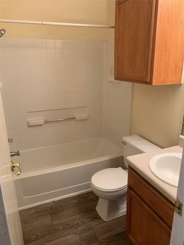 a white toilet and tub sitting next to a bathroom sink
