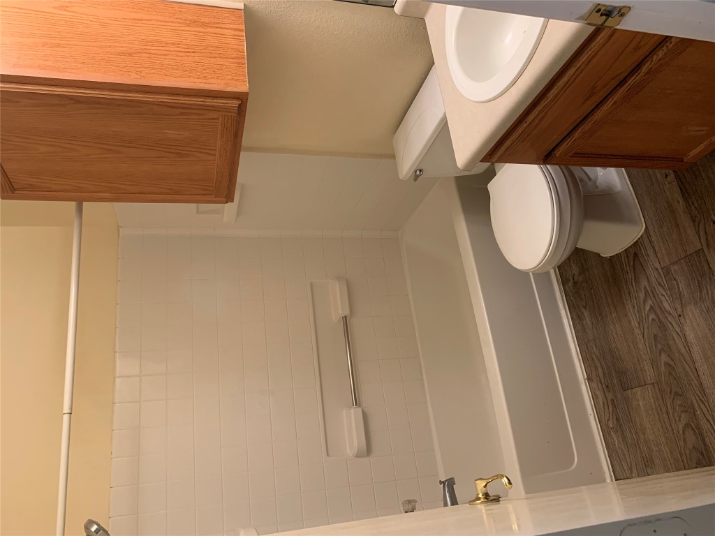 11904 Lima Drive Manor, TX 78653 - Photo 7 of 10 a white toilet and tub sitting next to a bathroom sink