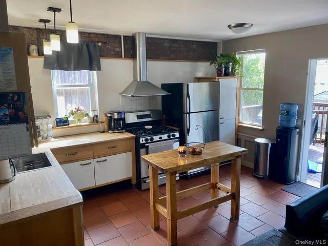 a room with furniture a flat screen tv and a refrigerator