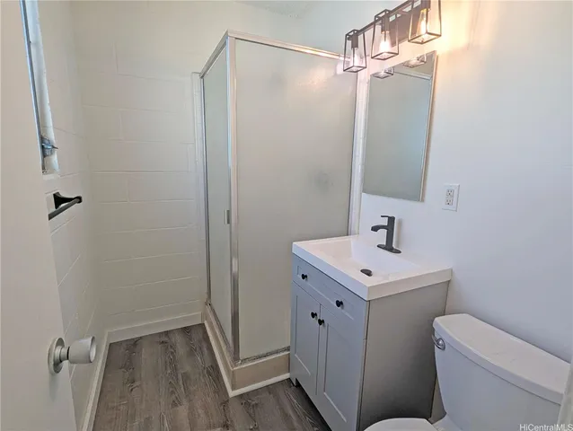 a bathroom with a sink a toilet a mirror and shower