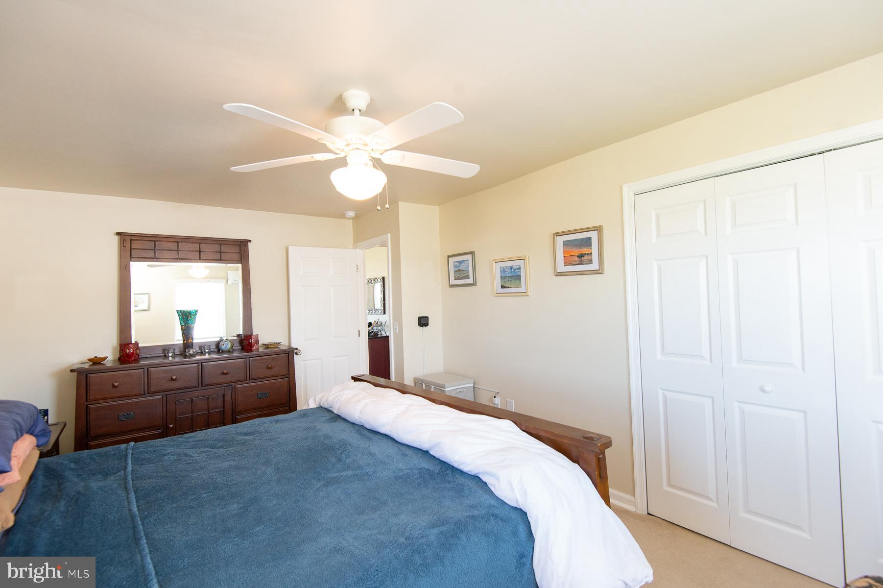 5558 Bowen Road Cambridge, MD 21613 - Photo 16 of 33 a bedroom with a large bed and a chandelier