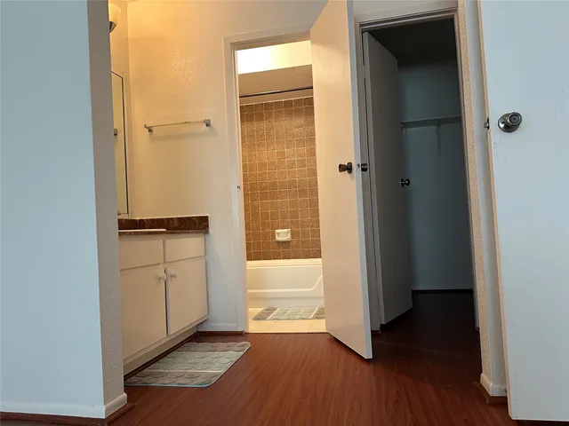 a view of walk in closet with wooden floor