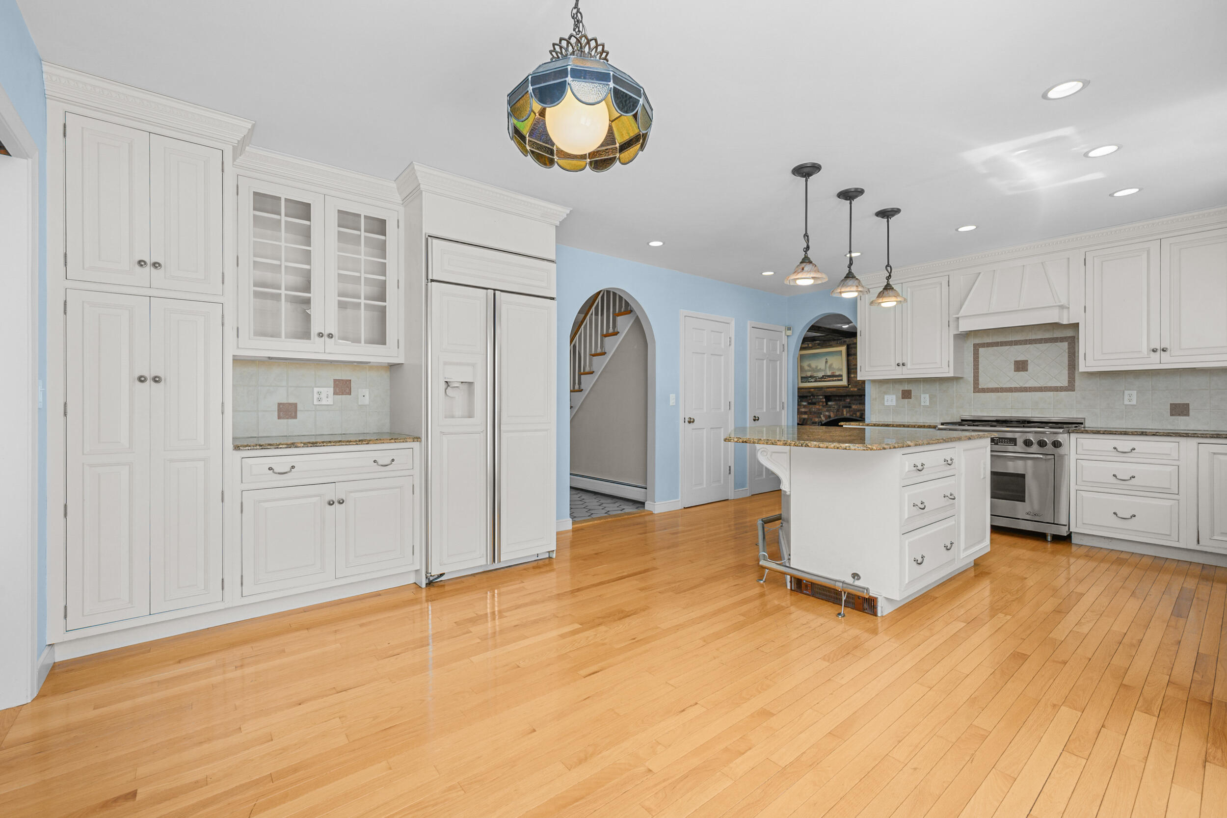 43 Sturgis Lane Barnstable, MA 02630 - Photo 19 of 70 a kitchen with stainless steel appliances granite countertop a stove a sink dishwasher and white cabinets with wooden floor