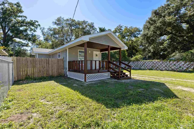 a view of a house with a yard patio and a garden