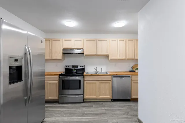 a kitchen with stainless steel appliances granite countertop a stove a refrigerator and a microwave