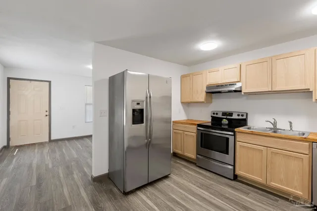 a kitchen with a sink a refrigerator and cabinets