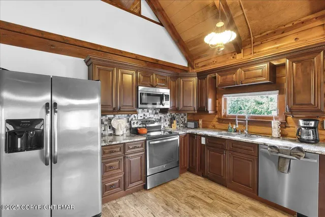 a kitchen with stainless steel appliances granite countertop a stove a sink and a refrigerator