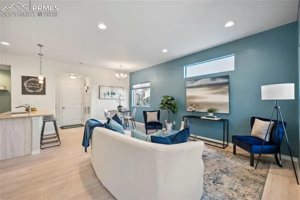 a living room with furniture a flat screen tv and a large window