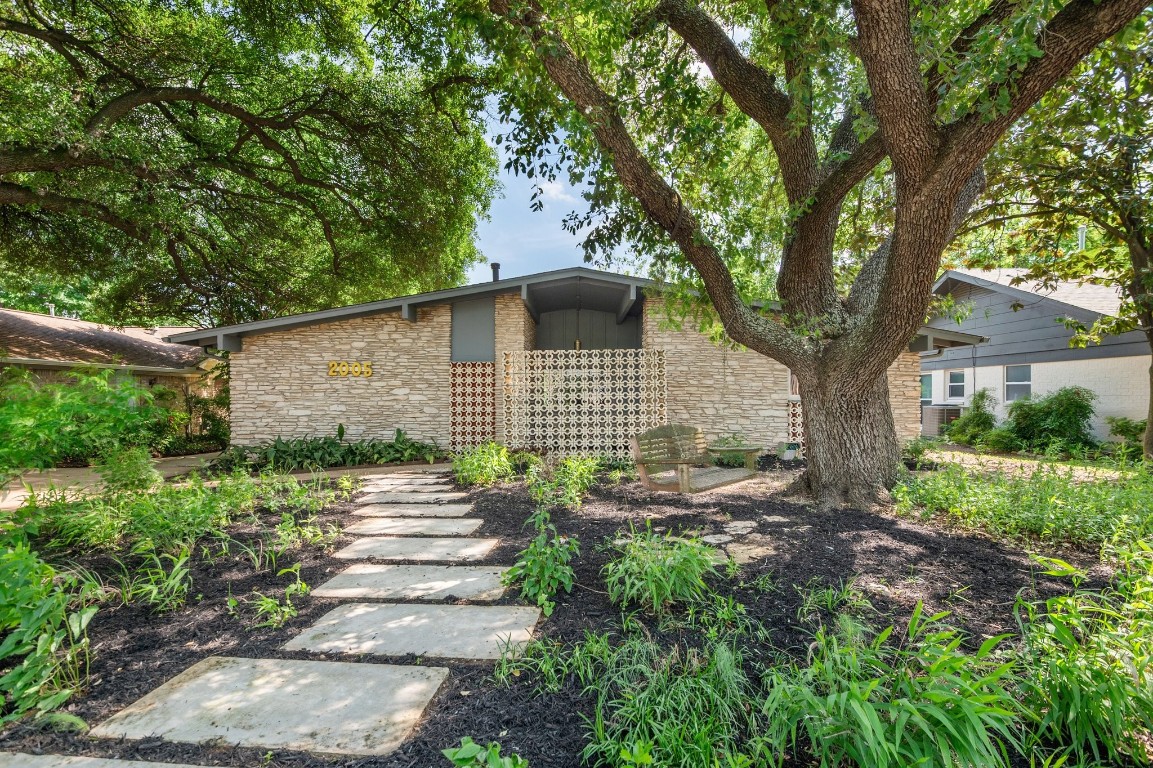 Beautiful front of home with mid-century charm and shade tree