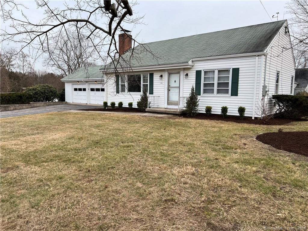 a view of a house with a yard and large tree