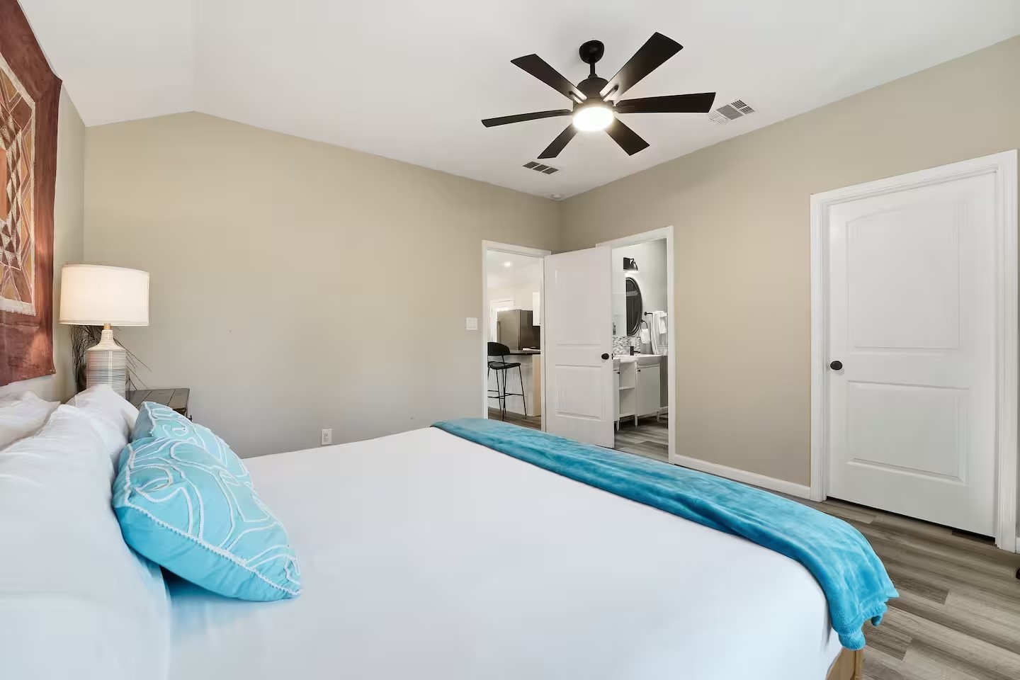 201 Winfield Thicket Road Bastrop, TX 78602 - Photo 27 of 36 a bedroom with a large bed and a chandelier