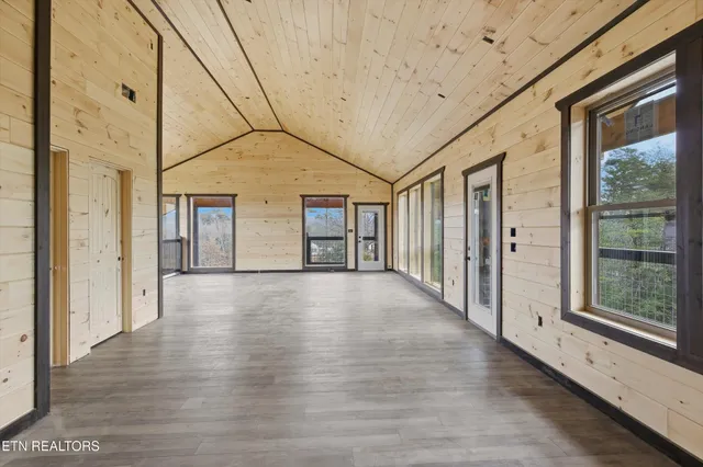 a view of a hall with wooden floor and windows