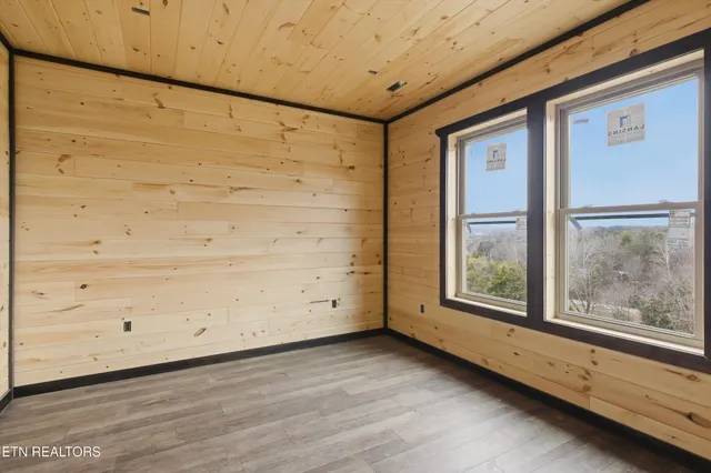 a view of a big room with wooden floor and windows