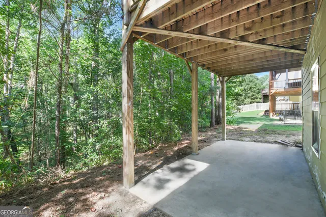 a backyard of a house with large trees and plants