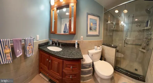 a bathroom with a granite countertop toilet sink and mirror