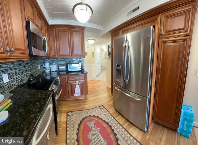 a kitchen with stainless steel appliances granite countertop a refrigerator a stove top oven a sink and dishwasher