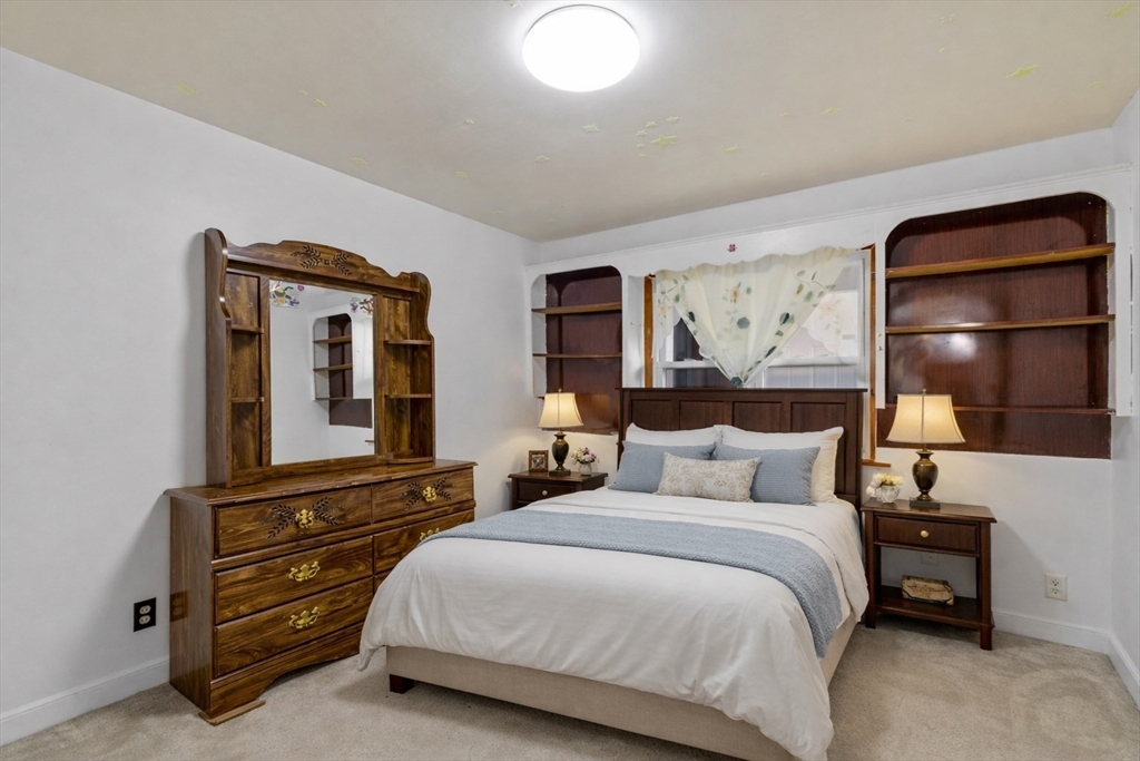 176 River Street Waltham, MA 02453 - Photo 13 of 32 a bedroom with a bed and a large mirror