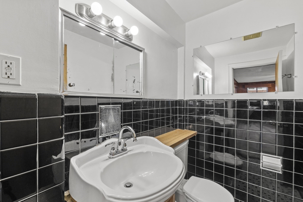 176 River Street Waltham, MA 02453 - Photo 17 of 32 a bathroom with a sink a toilet and a mirror