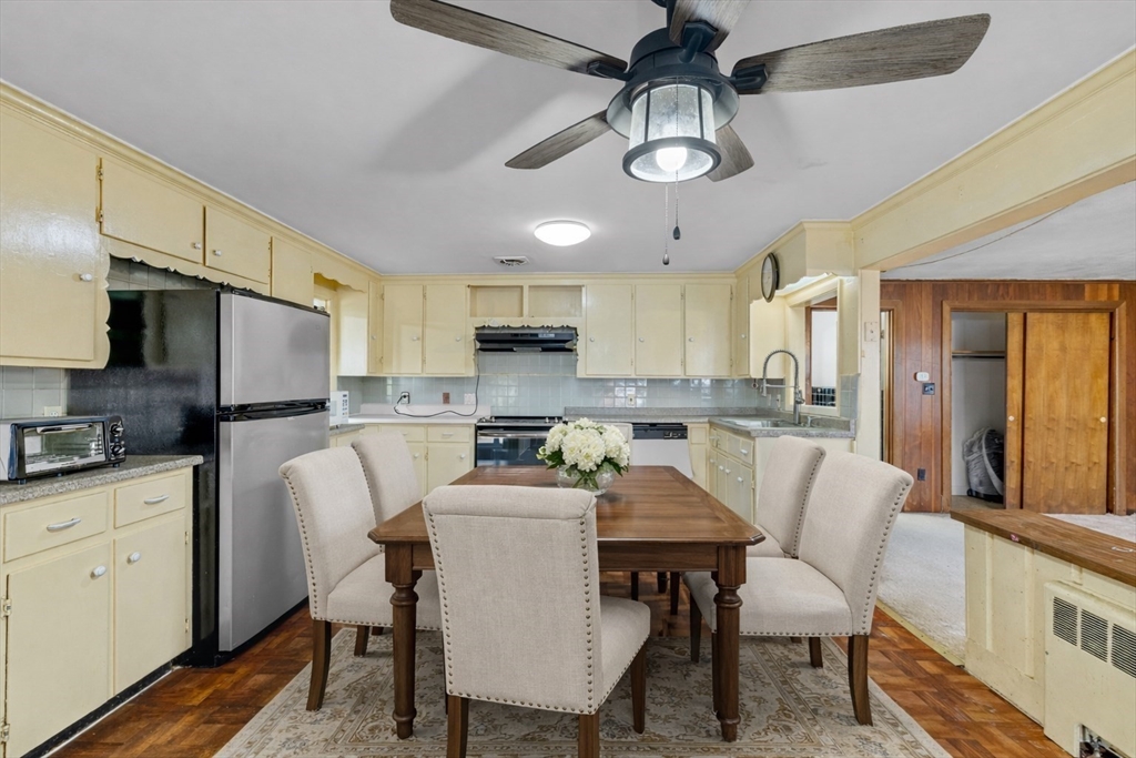 176 River Street Waltham, MA 02453 - Photo 3 of 32 a kitchen with stainless steel appliances kitchen island granite countertop a dining table chairs refrigerator and sink