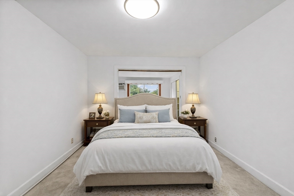 176 River Street Waltham, MA 02453 - Photo 9 of 32 a bedroom with a bed and a lamp