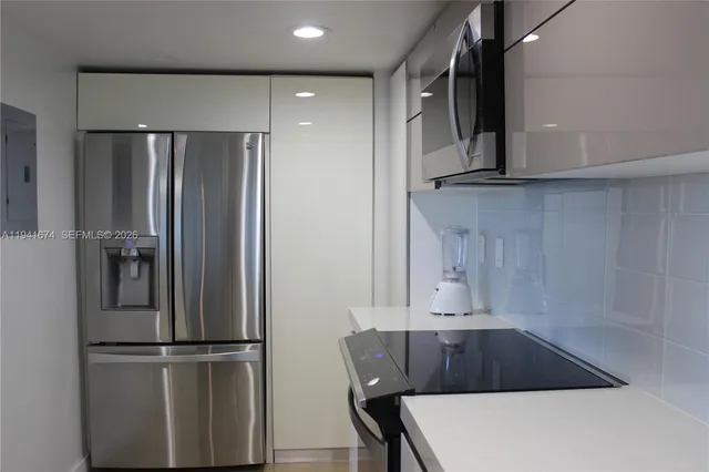 a kitchen with a refrigerator and a stove top oven