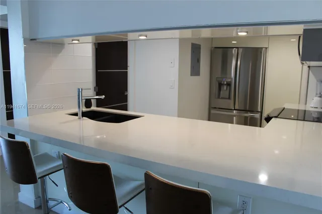 a kitchen with a table chairs and a refrigerator