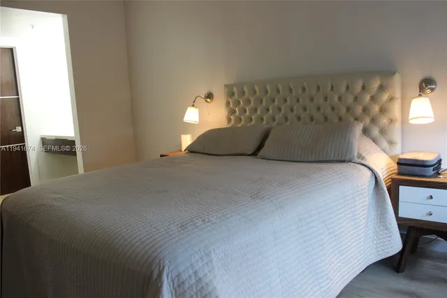 a large bed sitting in a bedroom next to a window