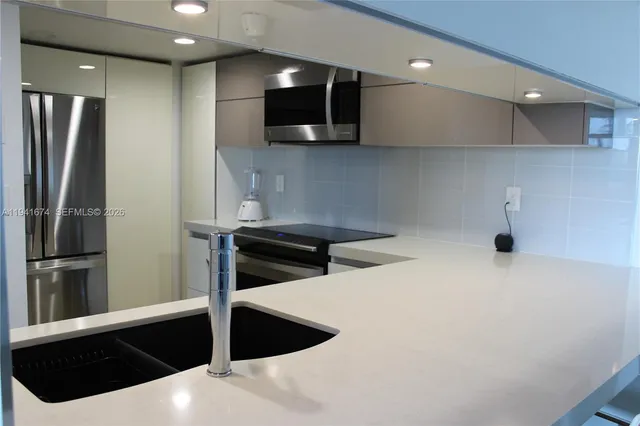 a kitchen with stainless steel appliances a refrigerator and a microwave