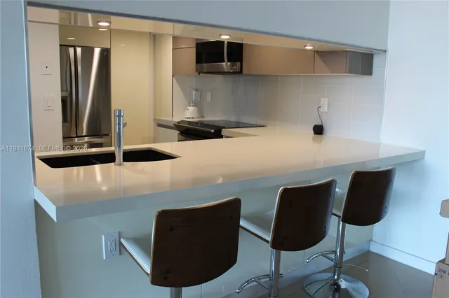 a kitchen with a table chairs and a refrigerator
