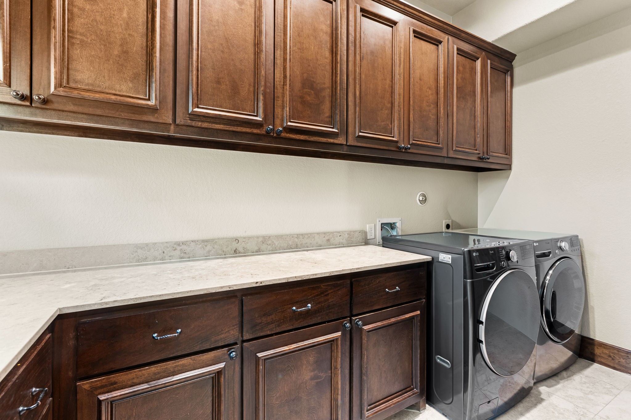 3751 Aberdeen Way Houston, TX 77025 - Photo 15 of 39 A well-appointed utility room with extensive built-in cabinetry, generous countertop workspace, and a clean, efficient layout designed for organized laundry and household tasks.