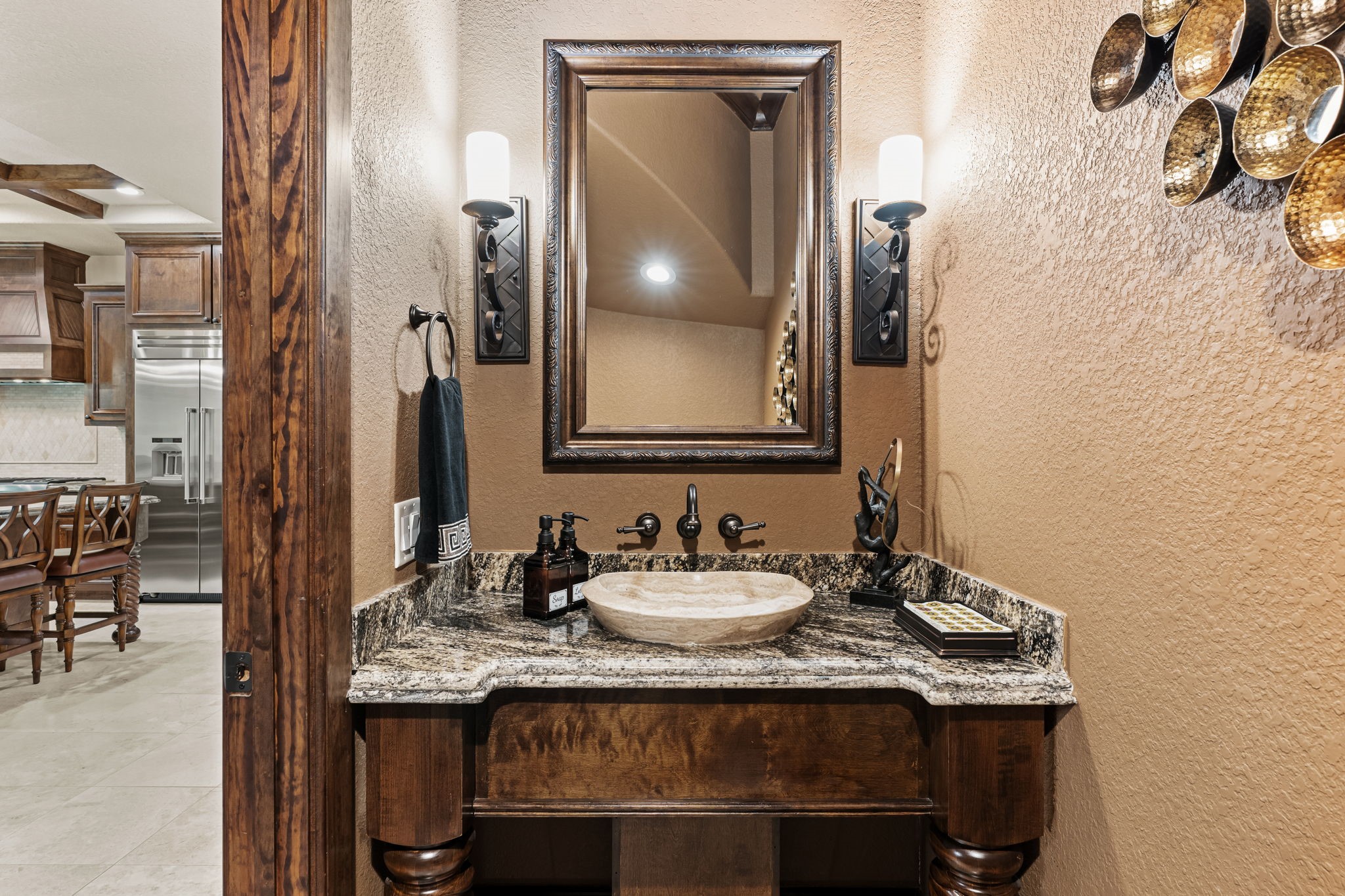 3751 Aberdeen Way Houston, TX 77025 - Photo 16 of 39 A stylish powder bath with custom stone countertops, a vessel sink, and warm textured walls, creating an elegant and intimate guest retreat.