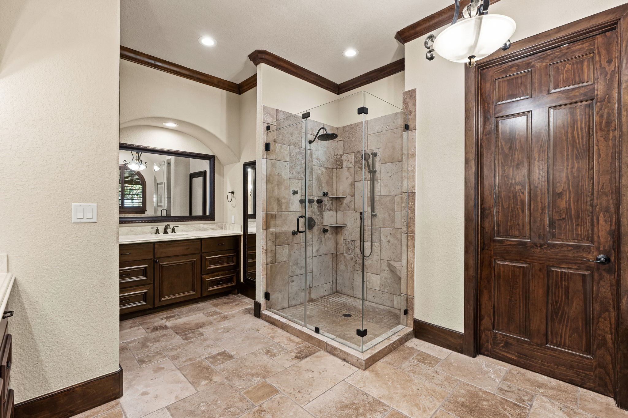3751 Aberdeen Way Houston, TX 77025 - Photo 18 of 39 A spa-inspired primary bath with a glass-enclosed walk-in shower, dual vanity, and elegant stone finishes, creating a serene and luxurious everyday retreat.