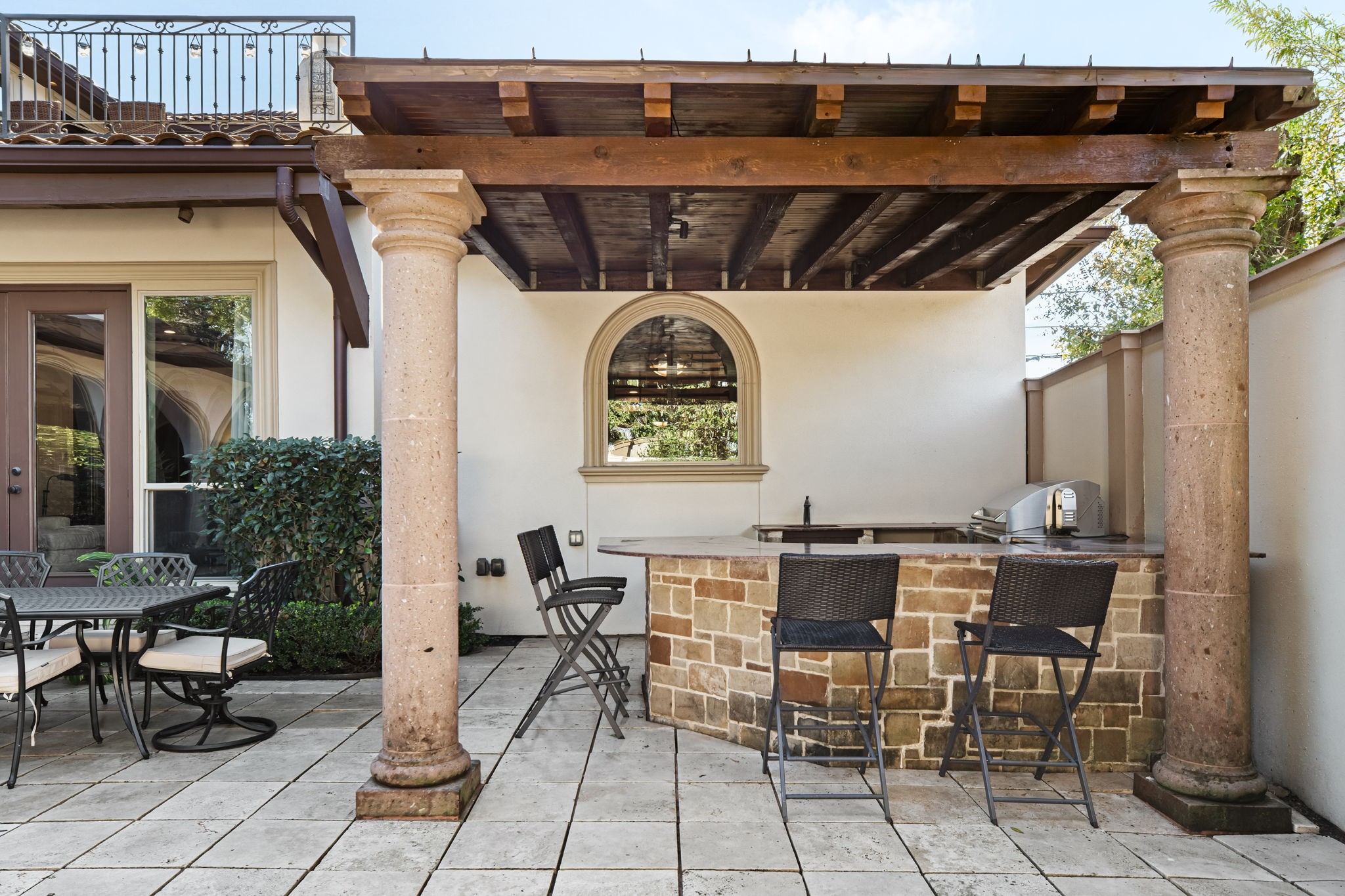 3751 Aberdeen Way Houston, TX 77025 - Photo 38 of 39 A covered outdoor kitchen featuring a built-in grill, stone-clad bar with seating, and integrated sink—perfectly designed for effortless entertaining and al fresco dining.