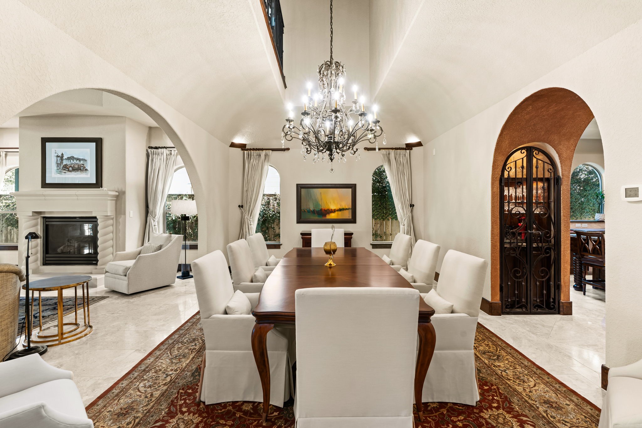 3751 Aberdeen Way Houston, TX 77025 - Photo 10 of 39 A dramatic open-concept dining space with vaulted ceilings and sweeping arched openings, seamlessly connecting multiple living areas and creating a light, expansive flow ideal for entertaining.